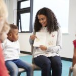 Female teacher showing a book to kindergarten children